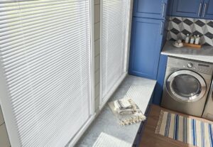 A laundry room with a close-up view of horizontal blinds